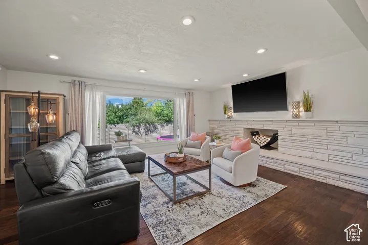 Bright, open living space anchored by a linear fireplace with horizontal shiplap surround and wall-mounted television