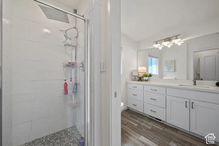 Glass-enclosed shower with a rainfall showerhead and mosaic tile flooring