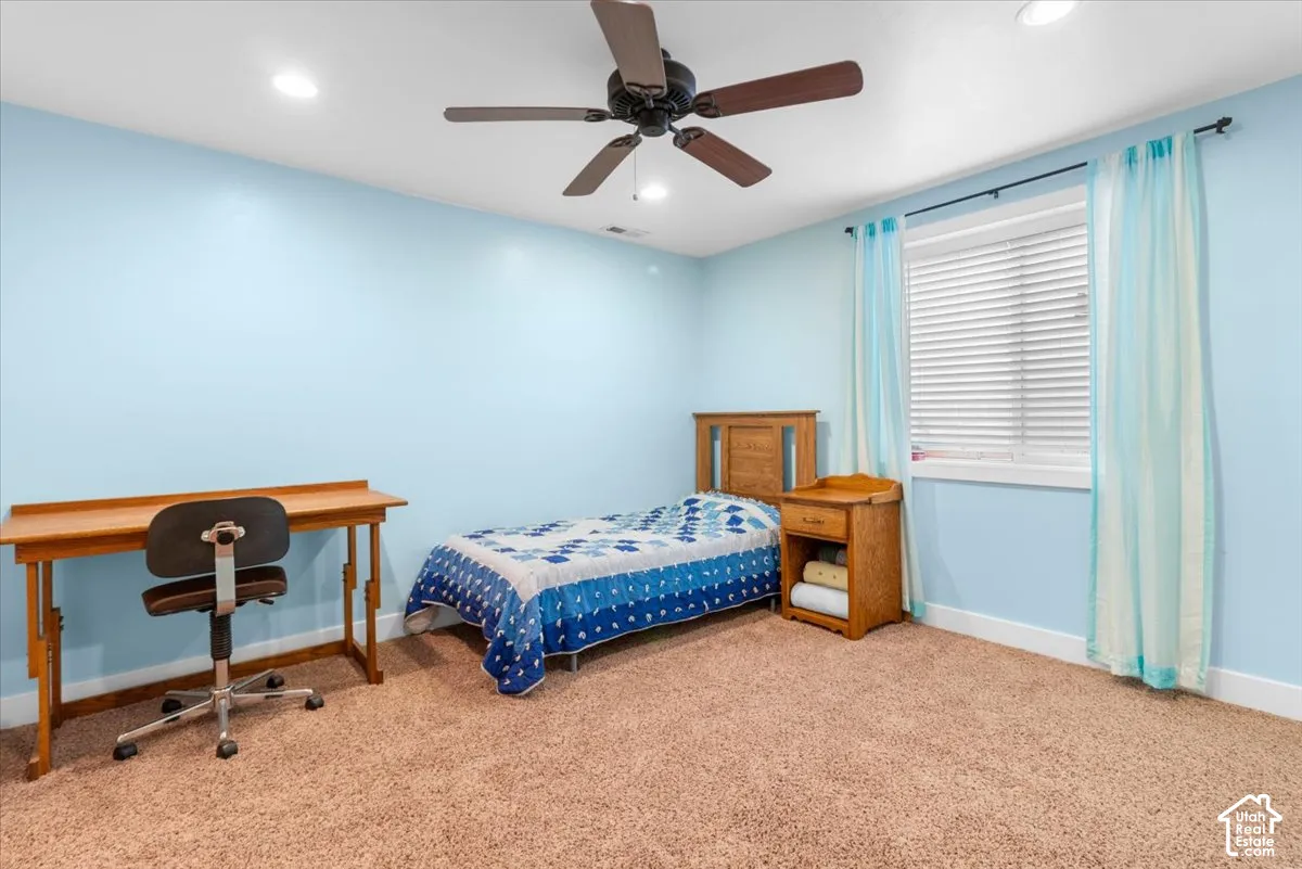 Recessed lighting, ceiling fan, window with blinds, light blue walls, and carpeted flooring