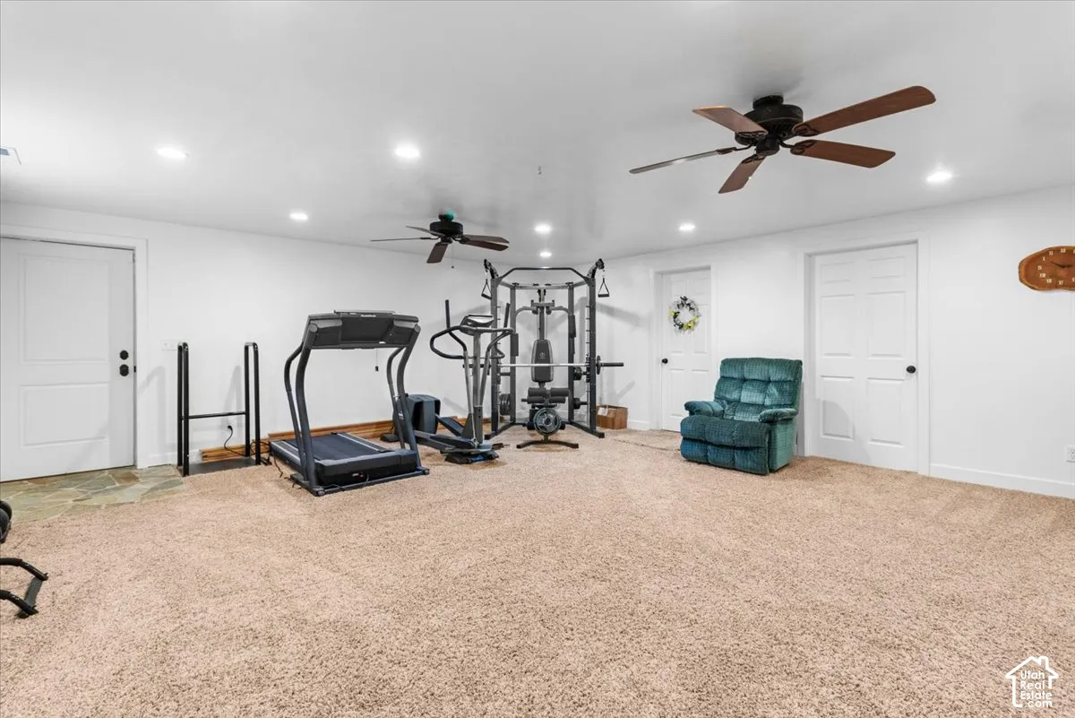 Carpeted room with recessed lighting and two ceiling fans
