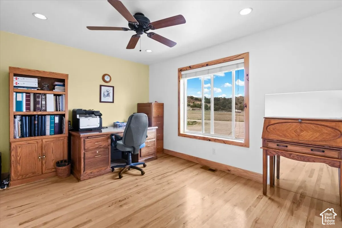 Hardwood flooring, recessed lighting, ceiling fan, and a built-in bookshelf