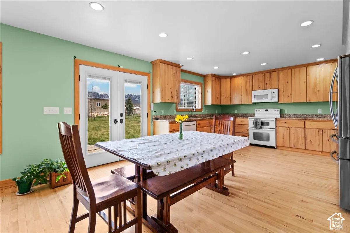 Kitchen featuring wood cabinetry, light wood-finish flooring, recessed lighting, and a double oven