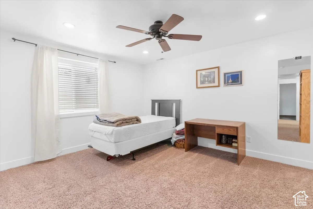 Carpeted room featuring a window with blinds, recessed lighting, and a ceiling fan