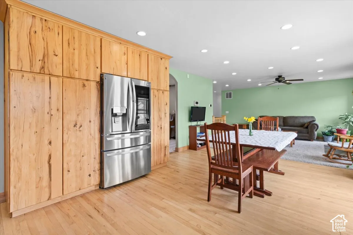 Hardwood flooring throughout, recessed lighting, built-in cabinetry, stainless steel refrigerator, and ceiling fan