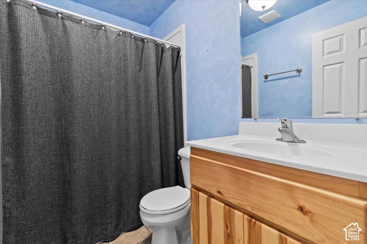 Full bathroom with wood-finish vanity with an integrated sink and chrome faucet