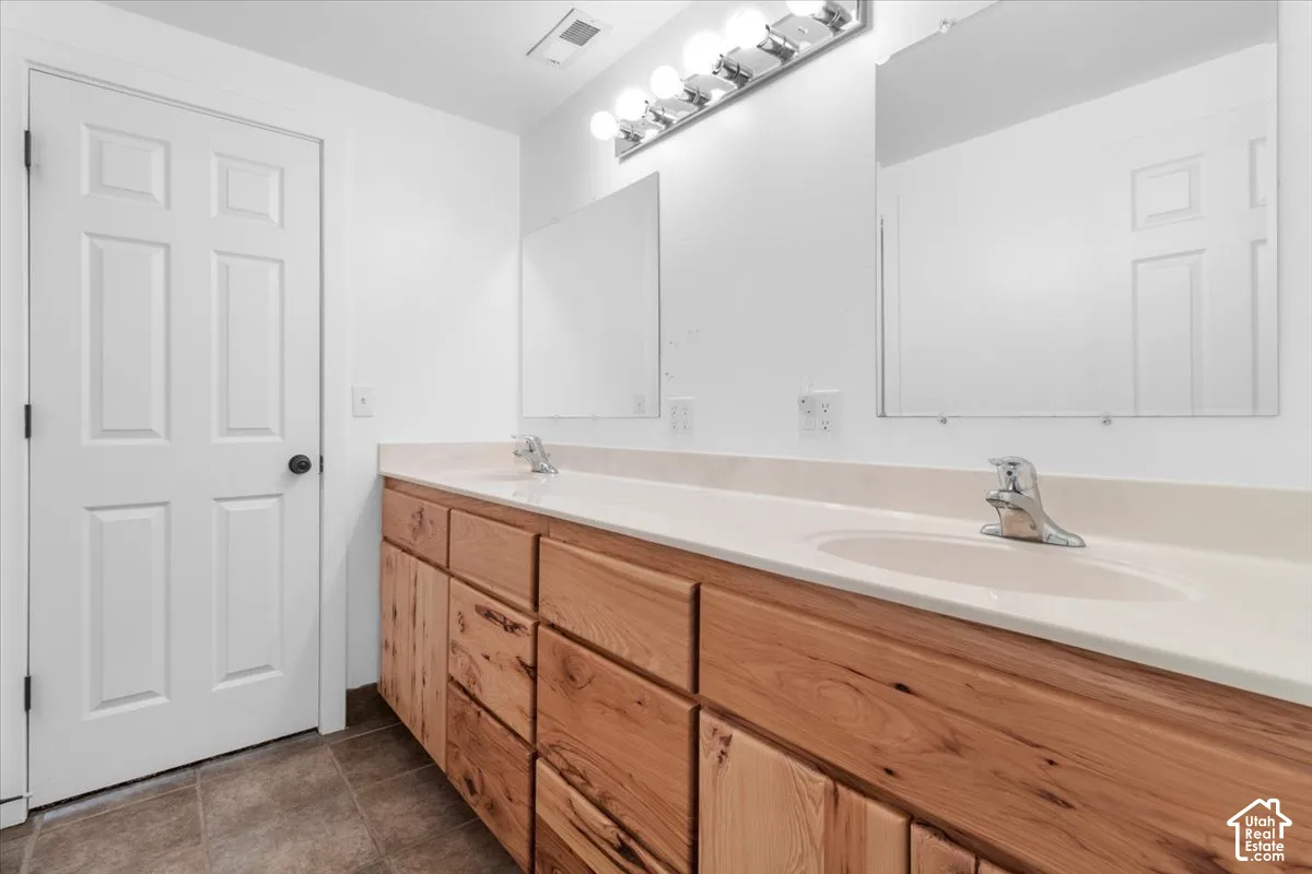 Dual vanity with wood-finish cabinetry, integrated sinks, chrome faucets, and two mirrors
