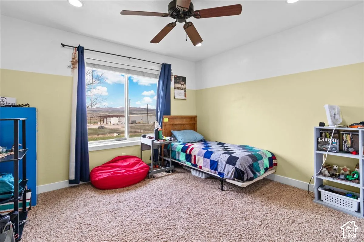 Recessed lighting, ceiling fan, large window, and light-colored carpeting