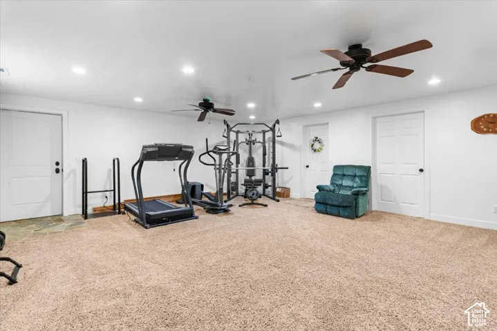 Carpeted room with recessed lighting and two ceiling fans
