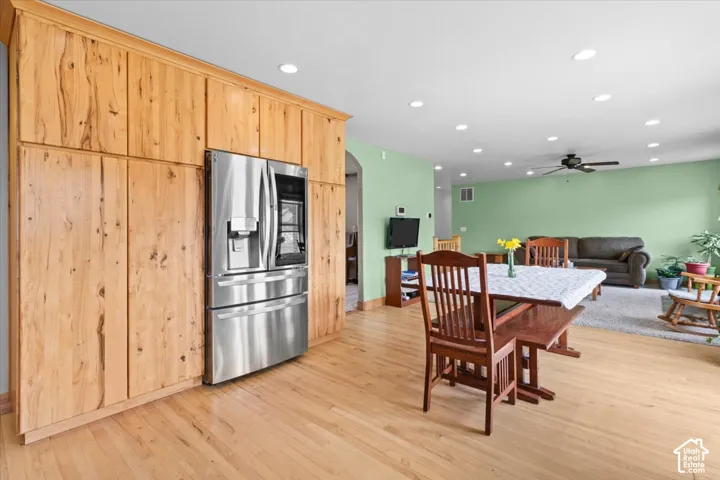 Hardwood flooring throughout, recessed lighting, built-in cabinetry, stainless steel refrigerator, and ceiling fan