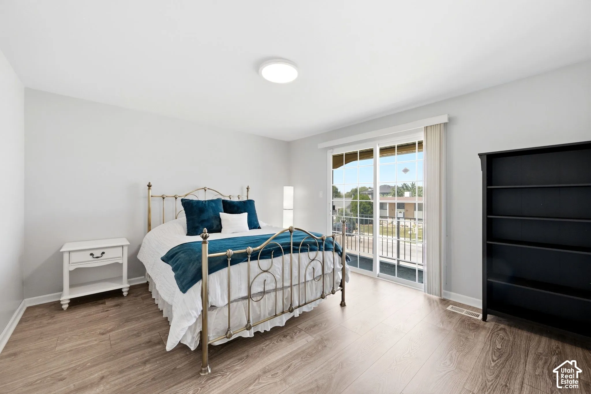 Wood-finish flooring, white walls, and a ceiling-mounted light fixture