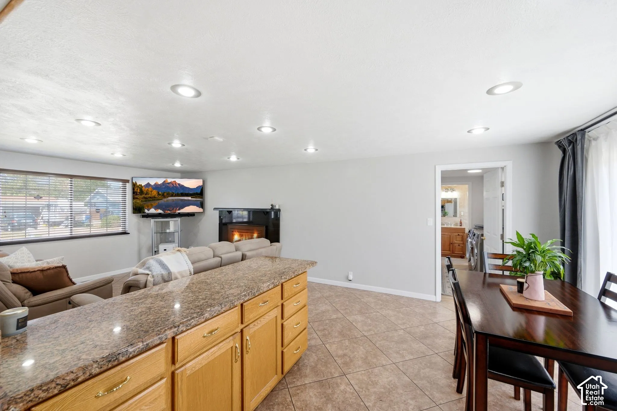 Kitchen island with wood cabinetry and a speckled countertop