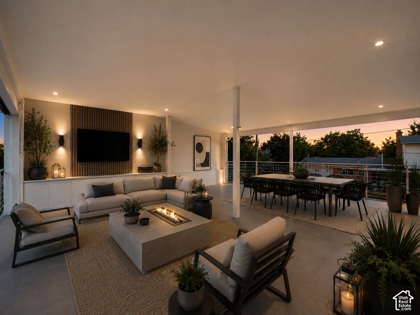 Expansive covered patio featuring a built-in media wall with integrated lighting, a concrete fire pit, and ample space for dining