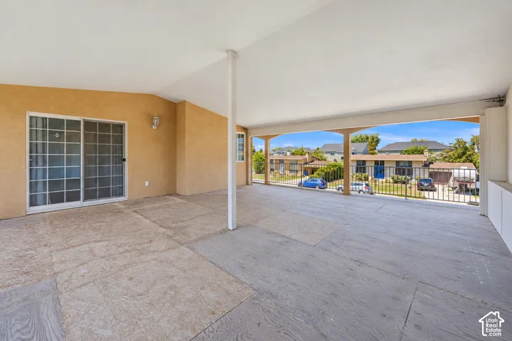 Covered patio with a concrete floor, stucco exterior, and sliding glass door