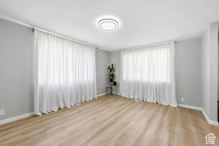 Bright interior space with wood-finish flooring, light gray walls, and recessed lighting