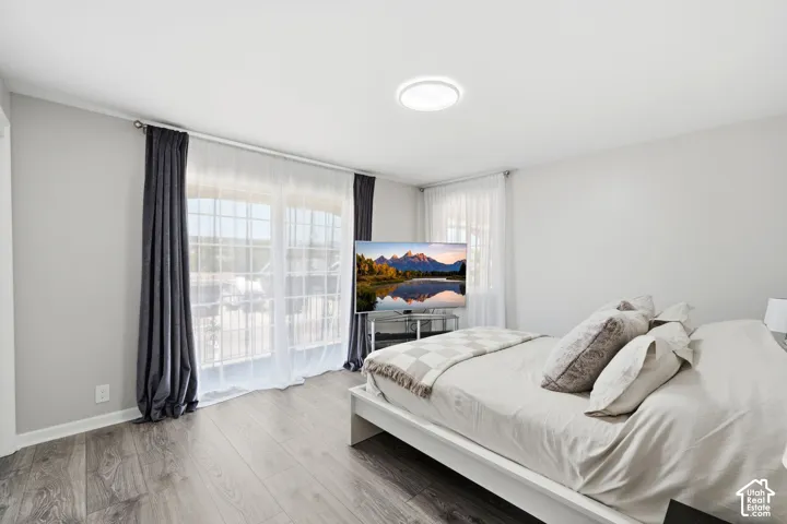 Hardwood-finish flooring, white walls, and a large window with white muntins