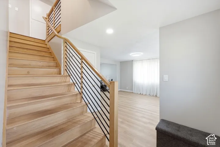 Staircase featuring wood steps and a black metal spindle railing