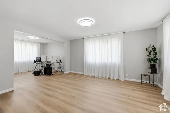 Recessed lighting, wood-finish flooring, and light gray wall paint