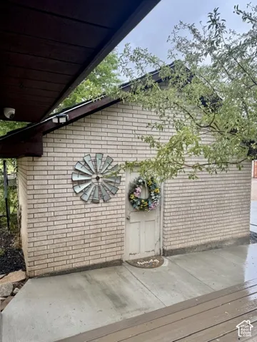 Brick exterior with a solid wood door and concrete patio