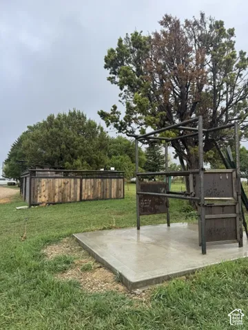 Concrete pad with a metal structure, surrounded by grass and mature trees
