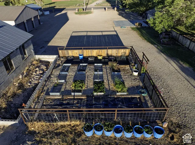 Fenced garden area featuring multiple raised beds and gravel pathways