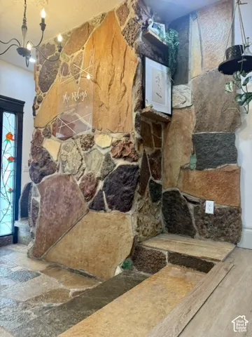Stone-clad fireplace featuring a multi-toned stone surround, stone hearth, and integrated stone shelving