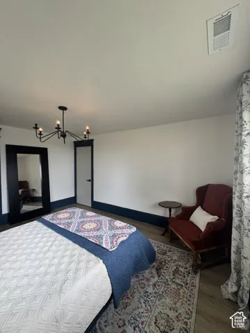 Recessed air vent, dark trim, and a black chandelier