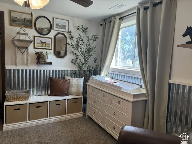 Galvanized wainscoting, ceiling fan, and carpeted flooring