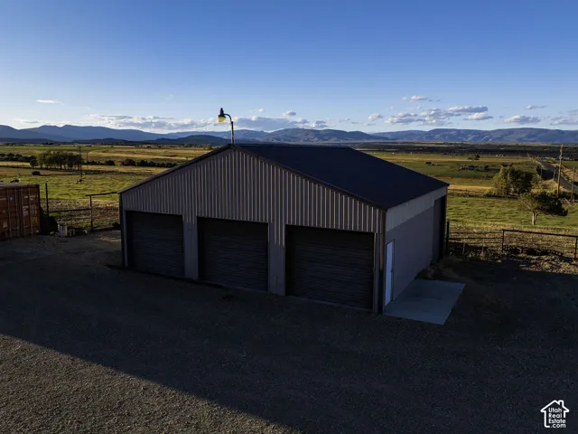 Metal-sided outbuilding with a dark roof, featuring three garage doors and a separate entry door