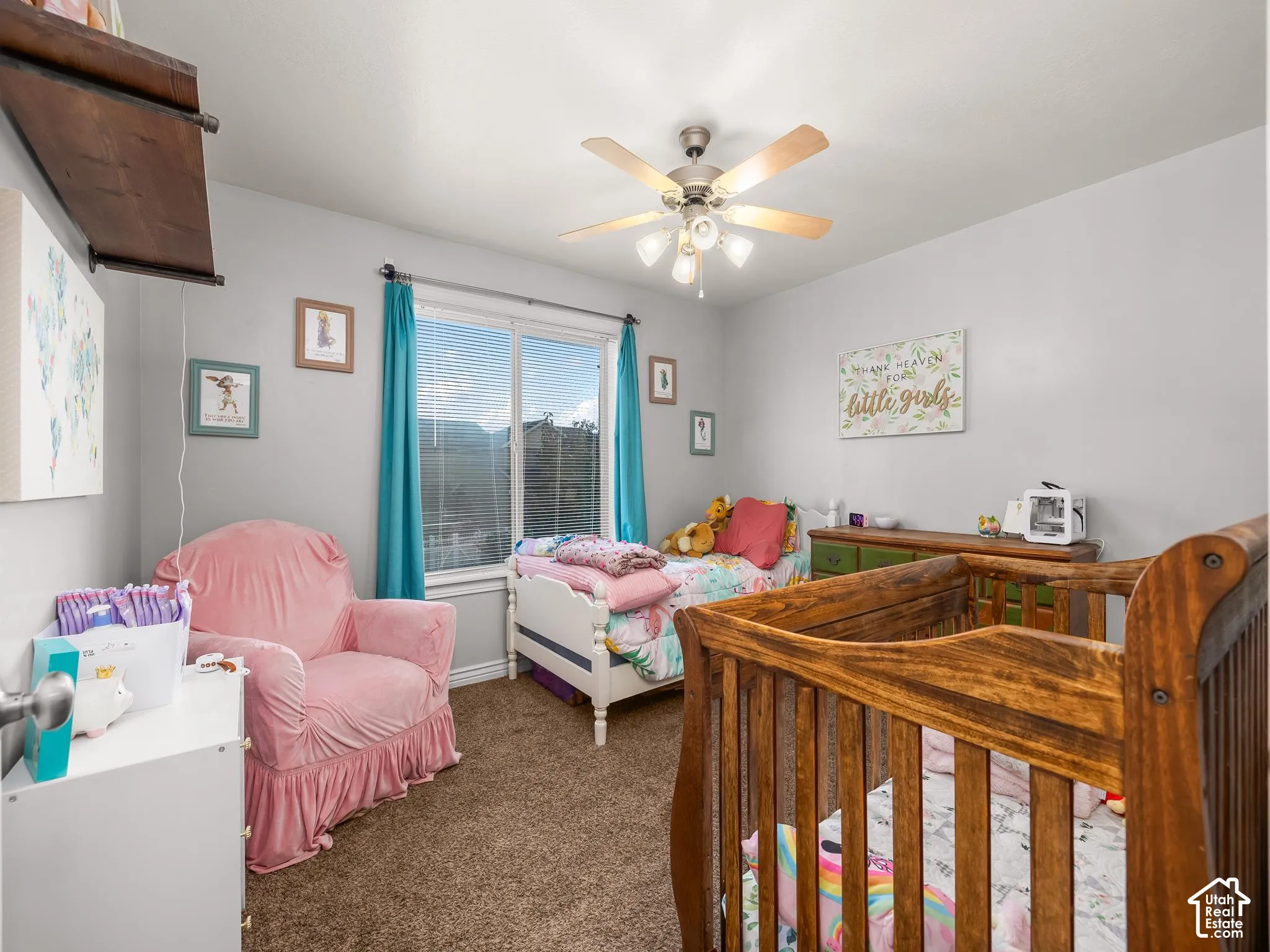 Window with exterior scenery, overhead ceiling fan with light fixture, wall-mounted shelving unit, and carpeted flooring