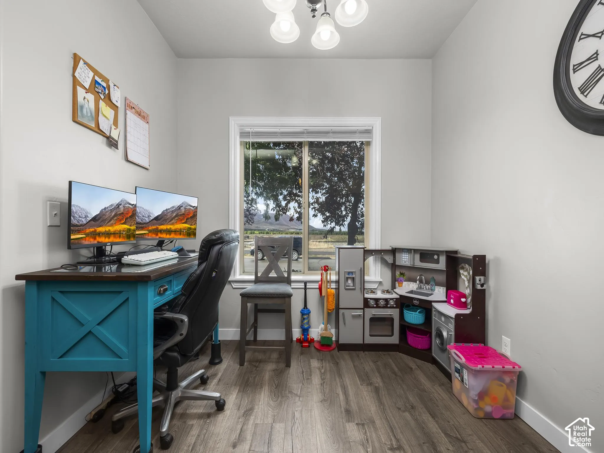 Neutral gray walls with wood-finish flooring and a single window offering natural light
