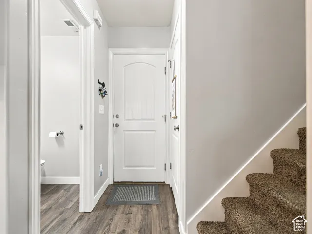 Wood-finish flooring, white paneled doors, and carpeted stairs
