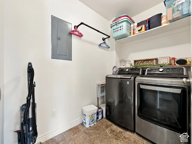 Laundry area featuring a built-in shelf, hanging rod, and textured floor tiling