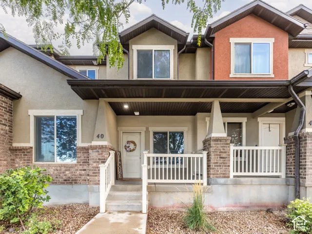 Entry porch with white railings, concrete steps, and recessed lighting