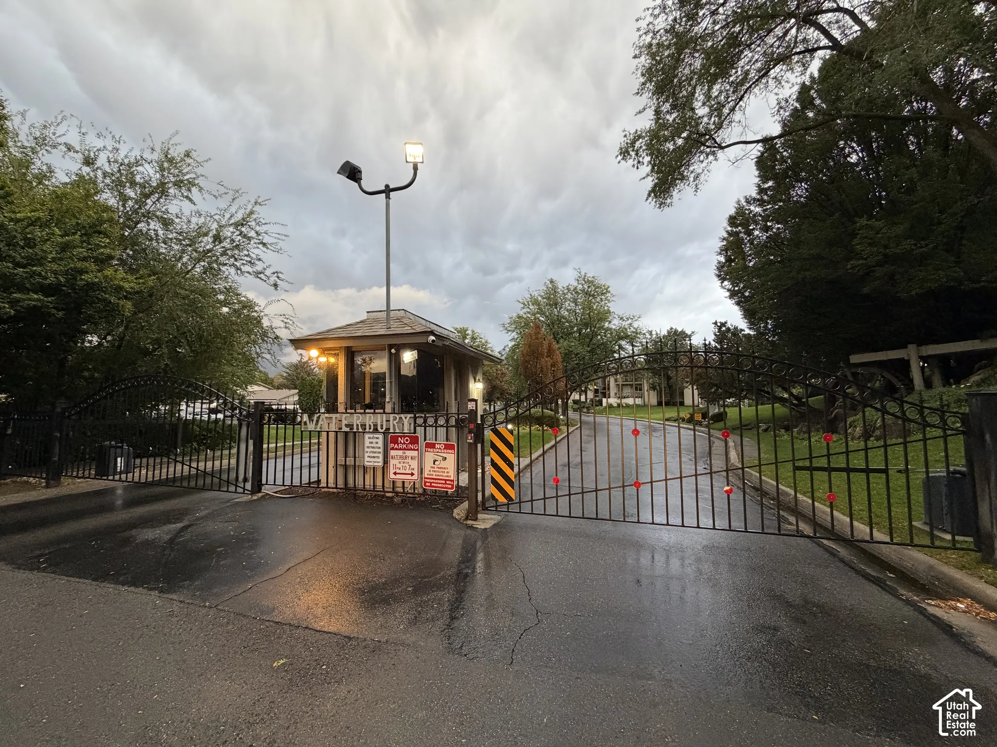 Gated entry with an attendant booth and black wrought iron gates