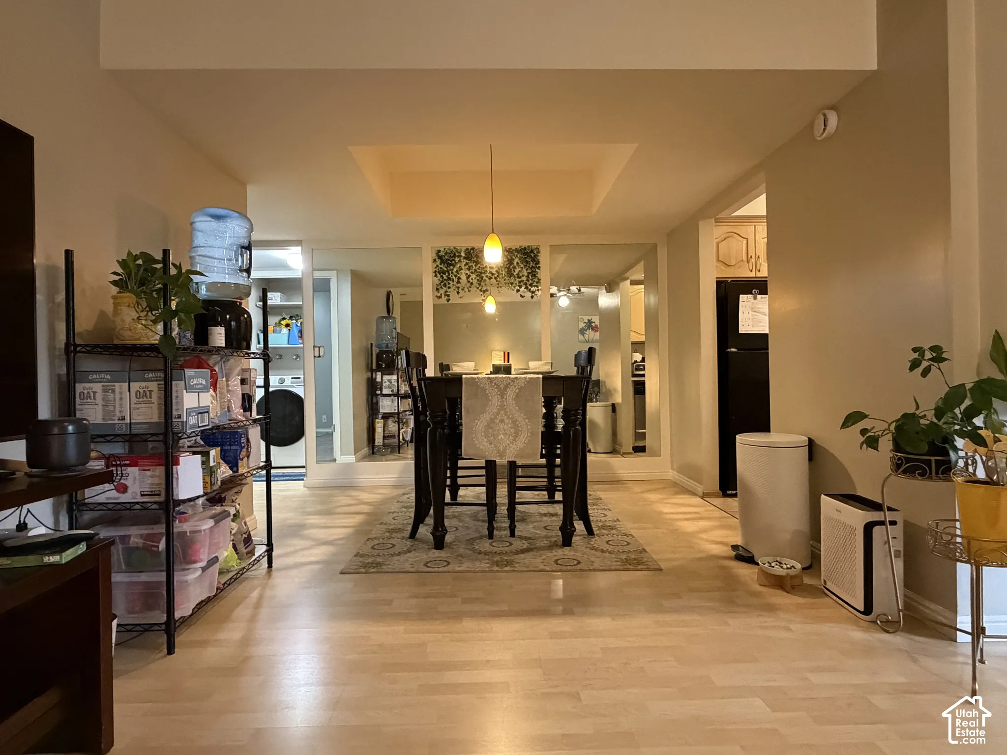 Light wood-finish flooring throughout, recessed ceiling detail, and ceiling-mounted pendant lighting