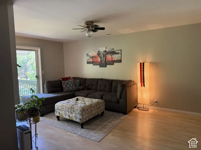 Neutral wall paint, ceiling fan with integrated lighting, wood-finish flooring, and a sliding glass door
