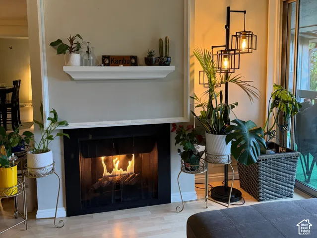 Fireplace with a black surround and white mantel, wood-finish flooring, and white trim detailing