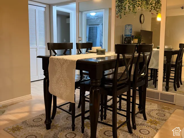Recessed ceiling with an integrated light panel, pendant light fixture, wood-finish flooring, and interior bi-fold doors