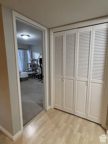 Light wood-finish flooring with white louvered bifold doors