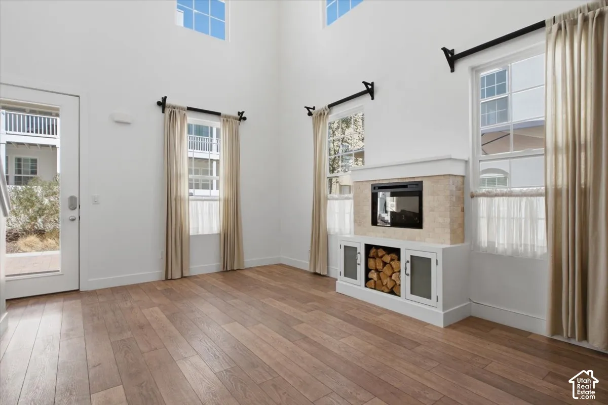 Vaulted ceilings, wood-finish flooring, built-in fireplace, built-in media console with glass-front cabinetry, transom windows