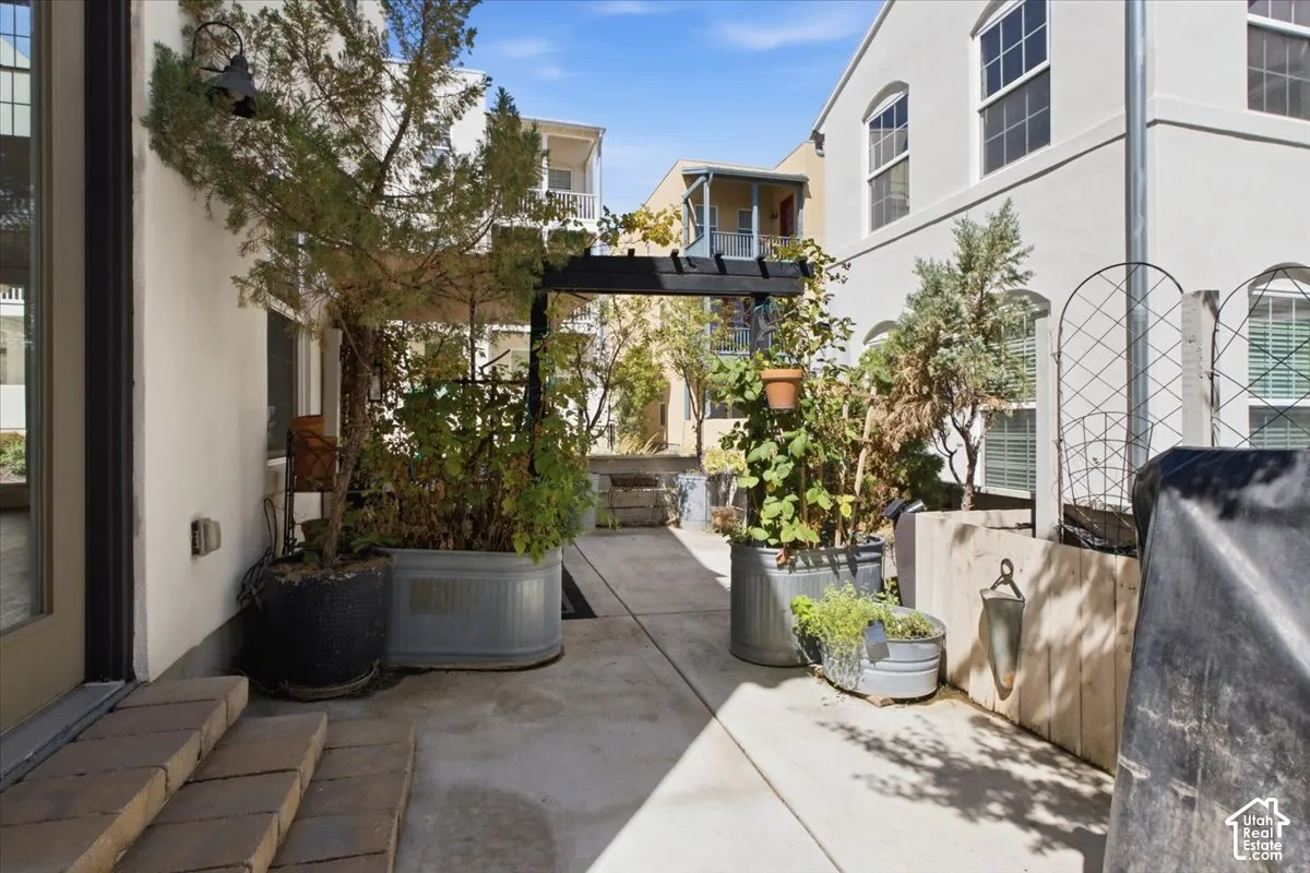 Concrete patio space with a dark wood pergola