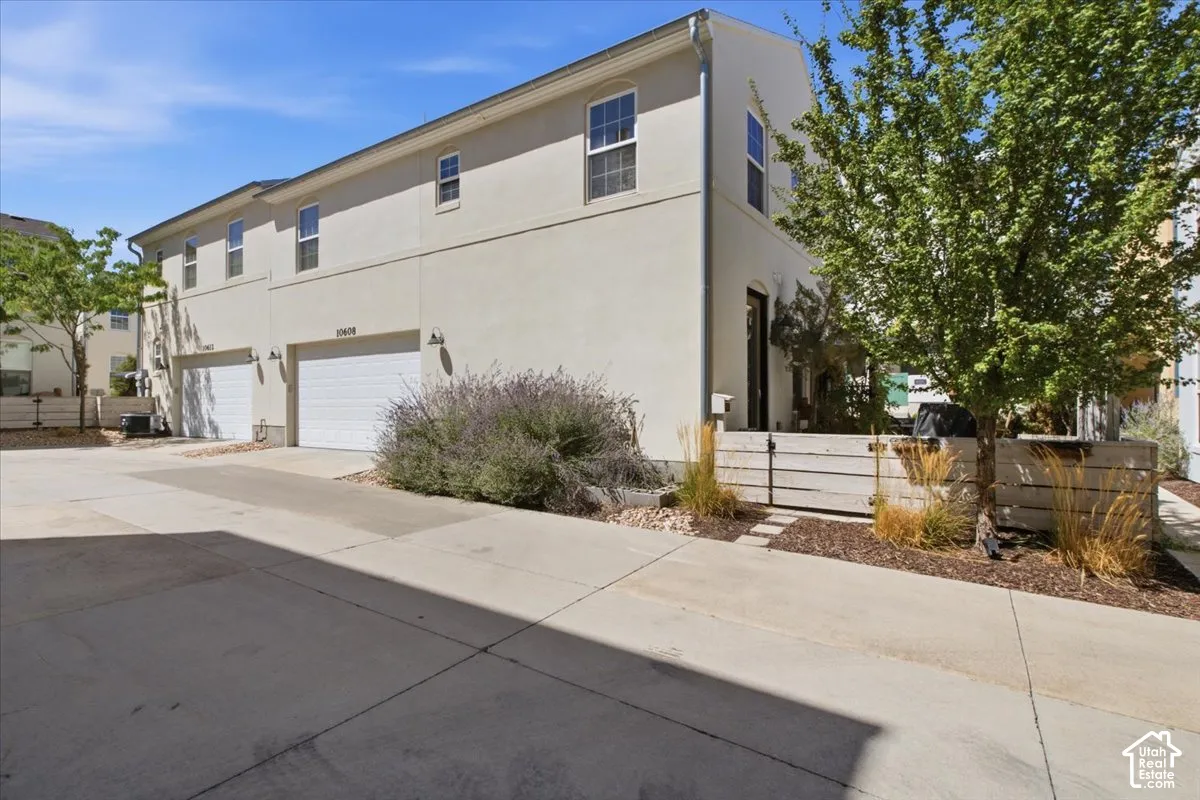 Two-story stucco exterior with multiple windows, featuring an integrated two-car garage