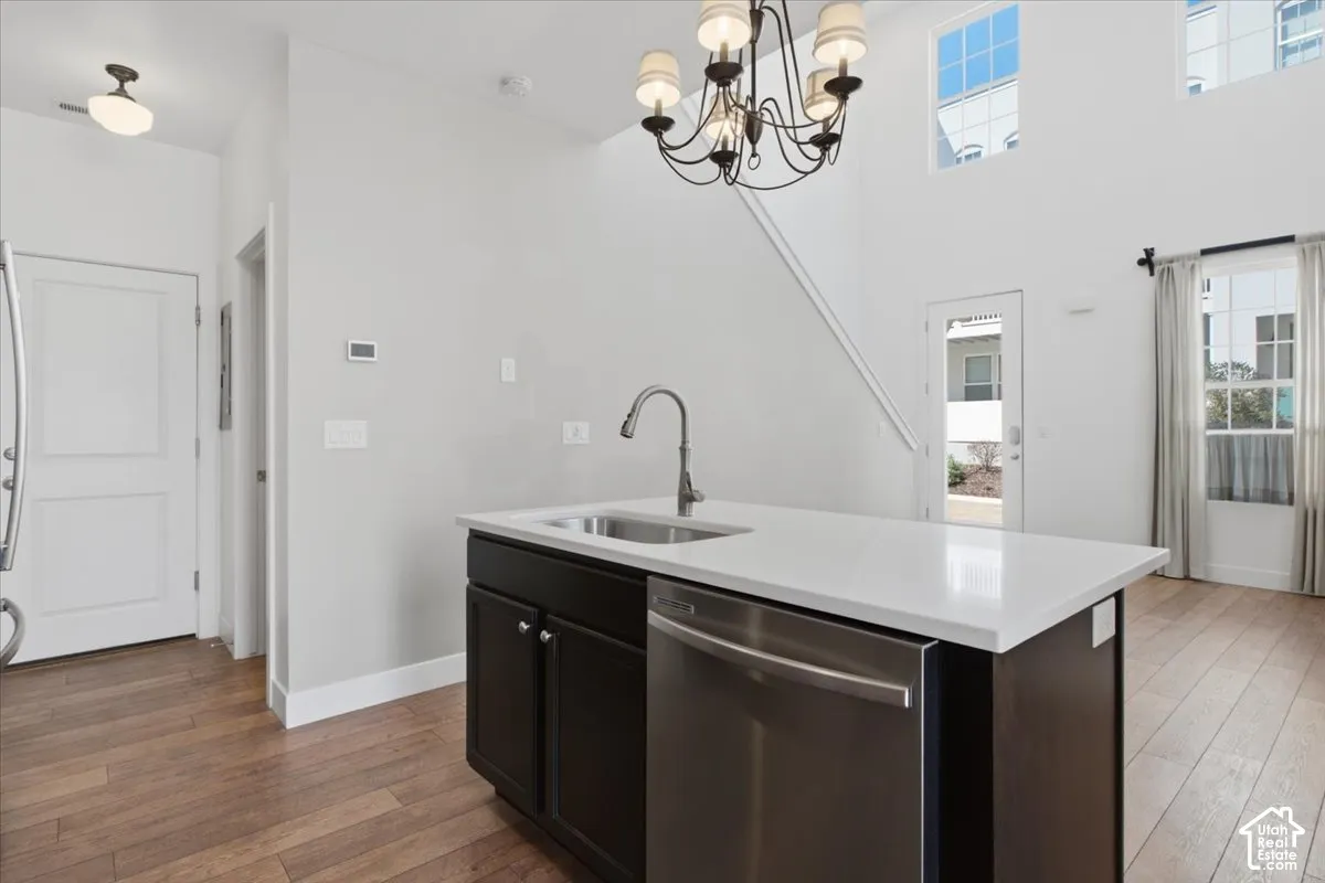 Kitchen island with a stainless steel sink, a pull-down faucet, and white countertop
