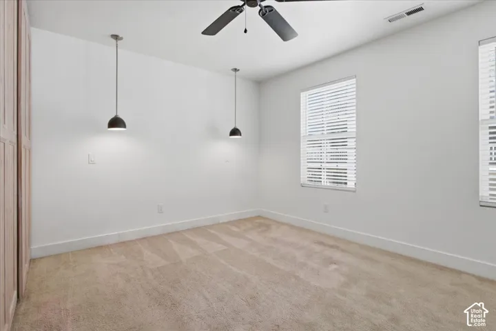 Neutral-toned carpeting, white walls, and multiple windows with blinds
