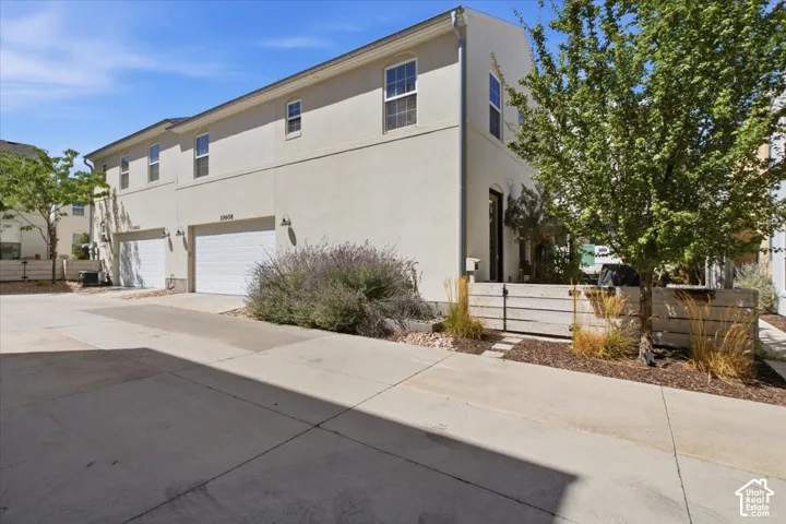 Two-story stucco exterior with multiple windows, featuring an integrated two-car garage