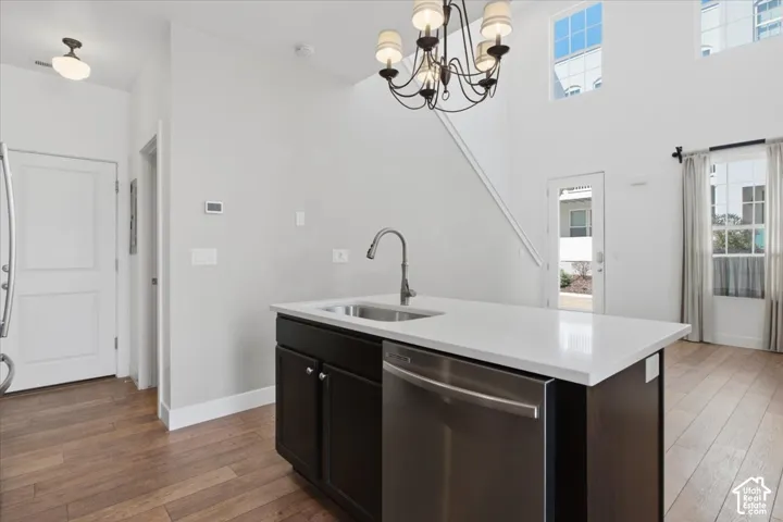 Kitchen island with a stainless steel sink, a pull-down faucet, and white countertop