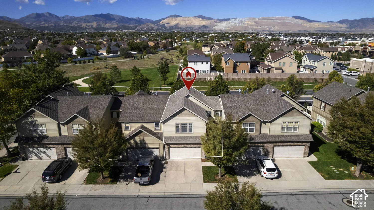 Townhome exterior with a two-car garage, concrete driveway, and mature landscaping