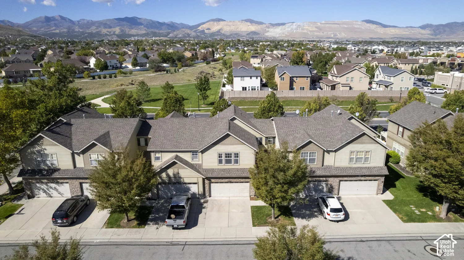 Attached townhome residences featuring multi-car garages, mature landscaping, and an adjacent park area