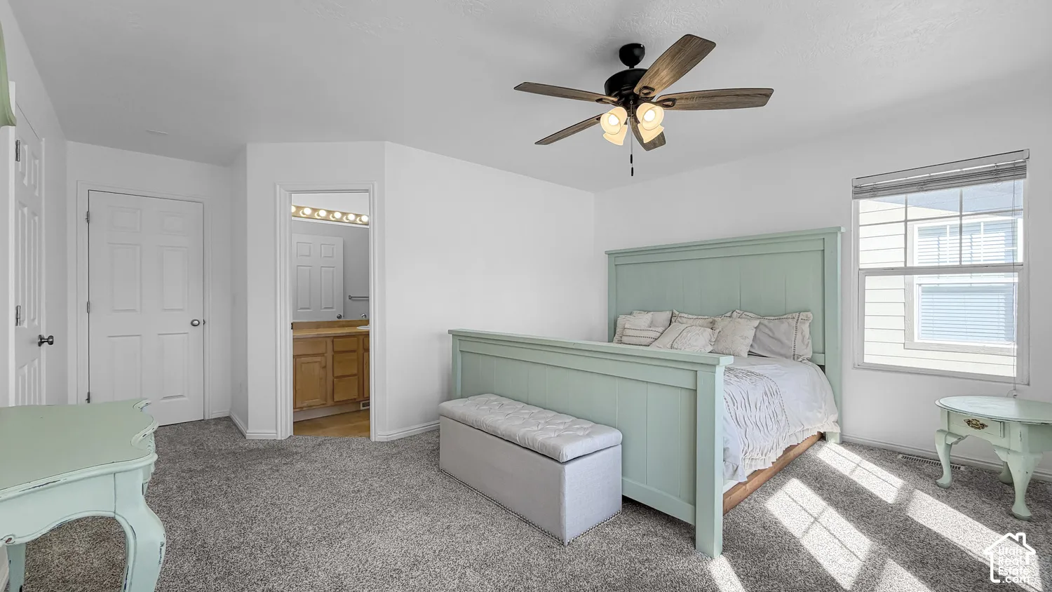 Plush carpet flooring, ceiling fan with integrated lighting, window with blinds, white paneled doors, and access to an adjoining space