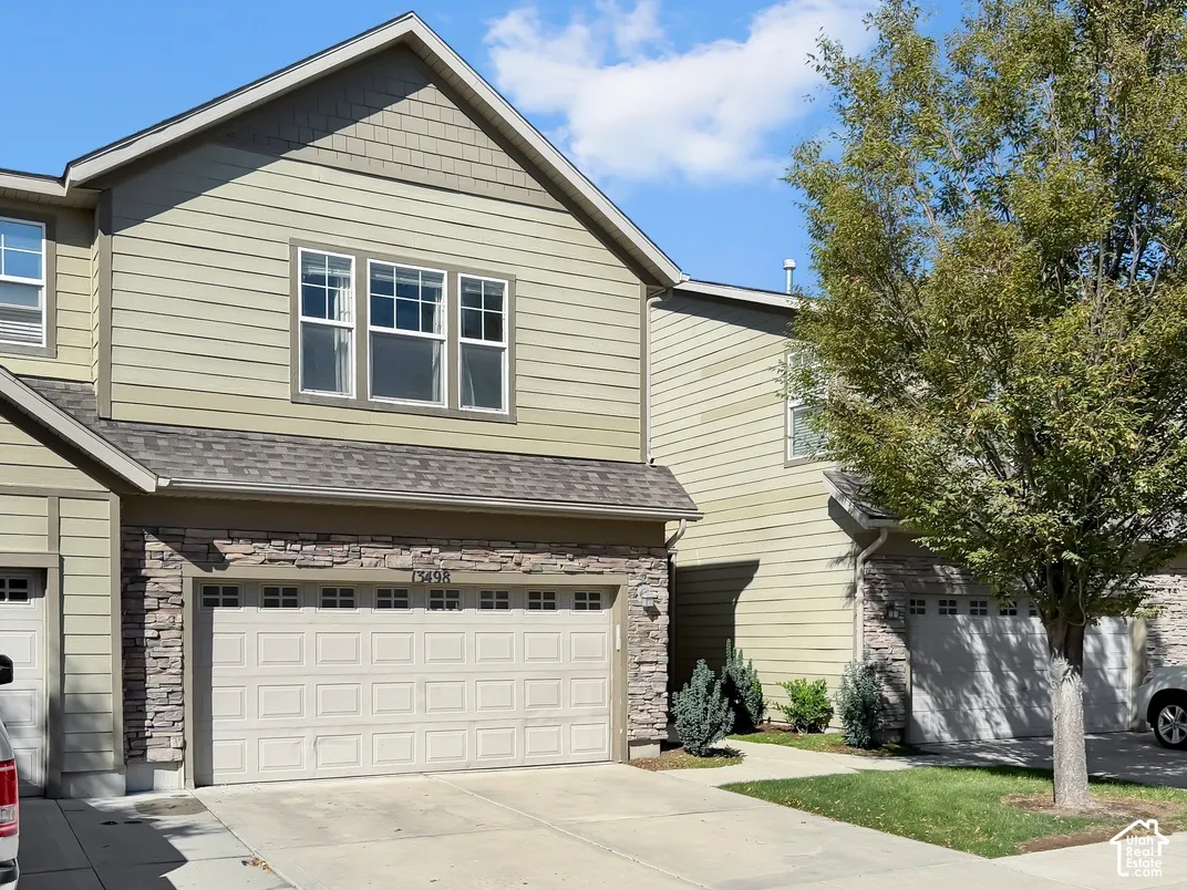 Two-story exterior with light green siding and stone accents